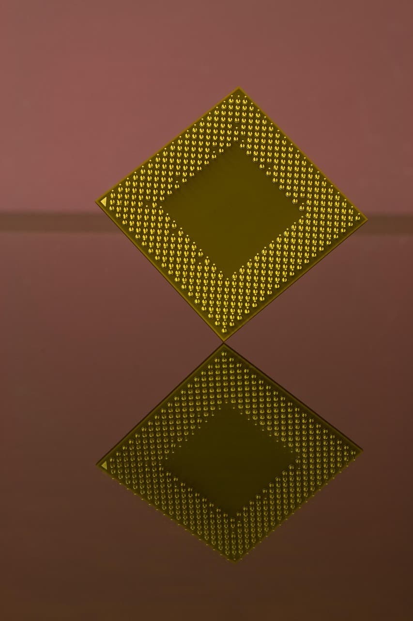 Extreme close-up of a computer CPU processor showing its grid pattern and metallic connectors, representing the silicon at the center of the domestic-versus-offshore fab debate.