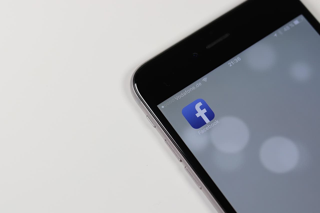 A smartphone screen displaying the Facebook application interface, representing Meta's core social platforms now subject to new safety restrictions under its child-safety settlement.